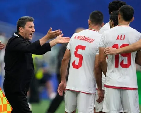 The Iran head coach, Amir Ghalenoei, gestures to his players during the World Cup draw against Egypt.